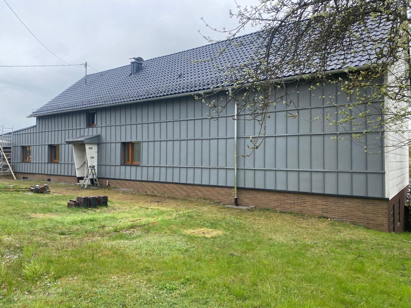 Projekt 3 - Nachher Fassade mit Metallverkleidung und Querunterbrechungen auf Fensterhöhe